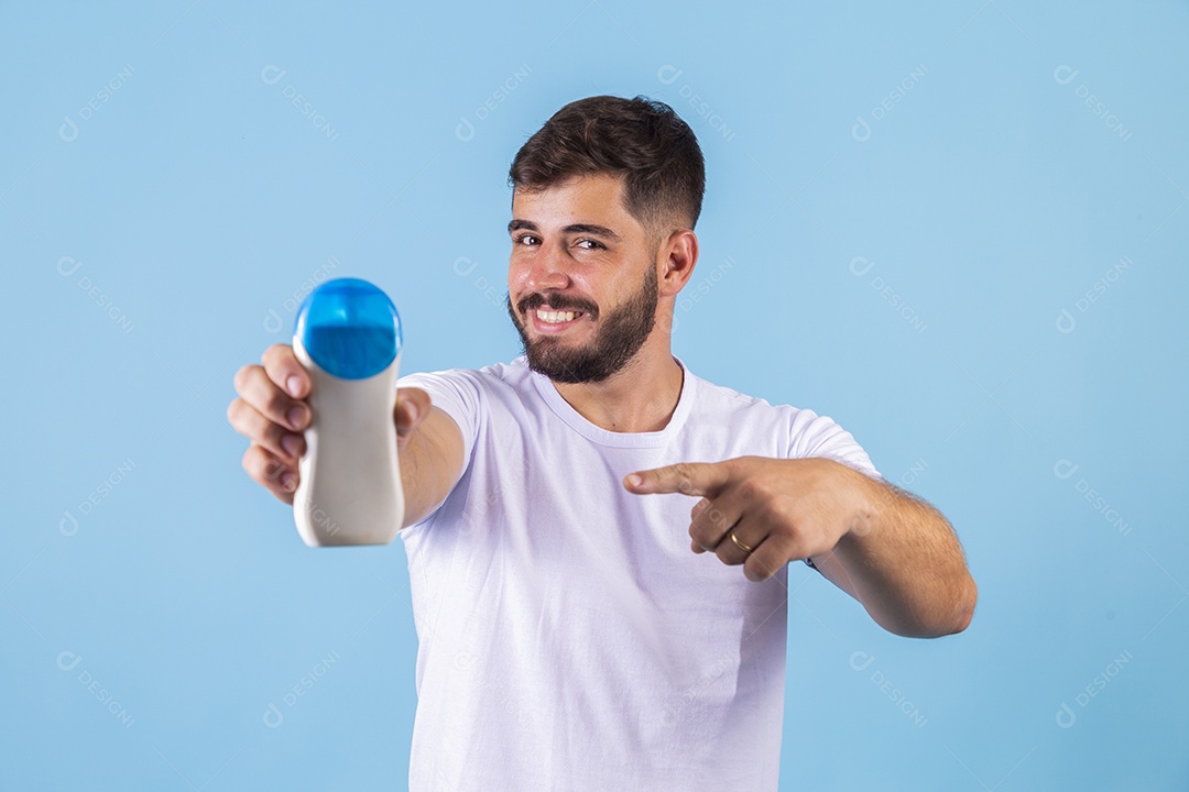 Homem jovem segurando frasco de produto para o rosto sobre fundo isolado