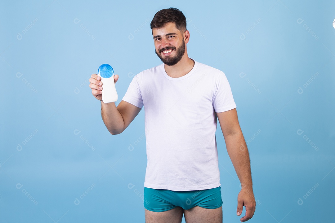 Homem jovem usando produto para o rosto sobre fundo isolado