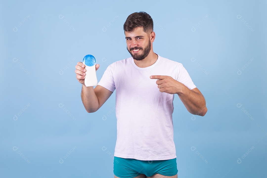 Homem jovem usando produto para o rosto sobre fundo isolado