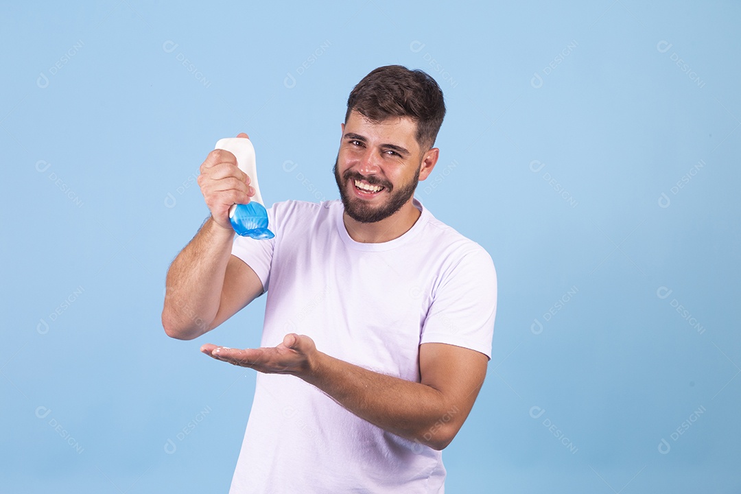 Homem jovem usando produto para o rosto sobre fundo isolado
