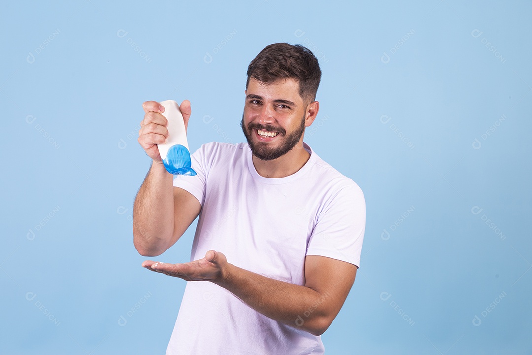 Homem jovem usando produto para o rosto sobre fundo isolado