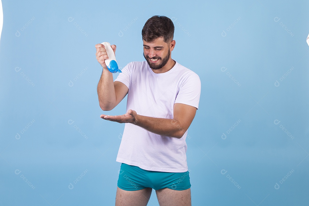 Homem jovem usando produto para o rosto sobre fundo isolado