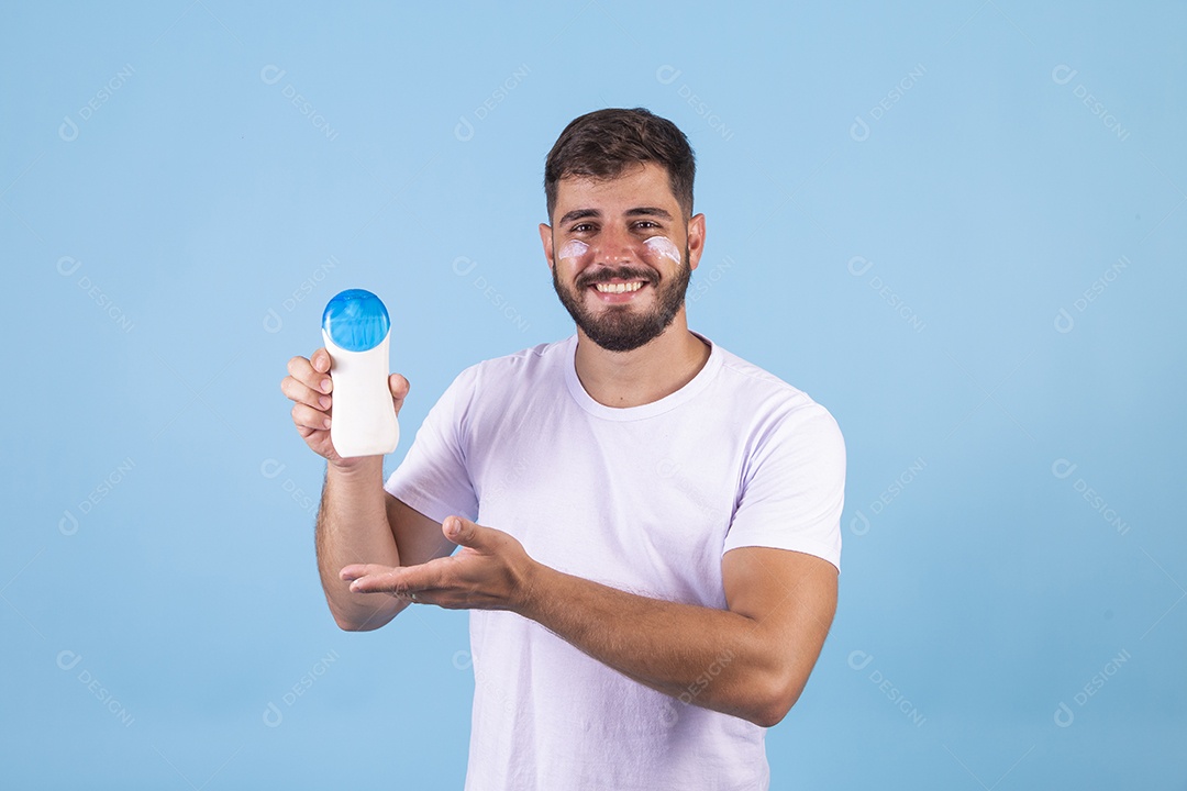 Homem jovem usando produto para o rosto sobre fundo isolado