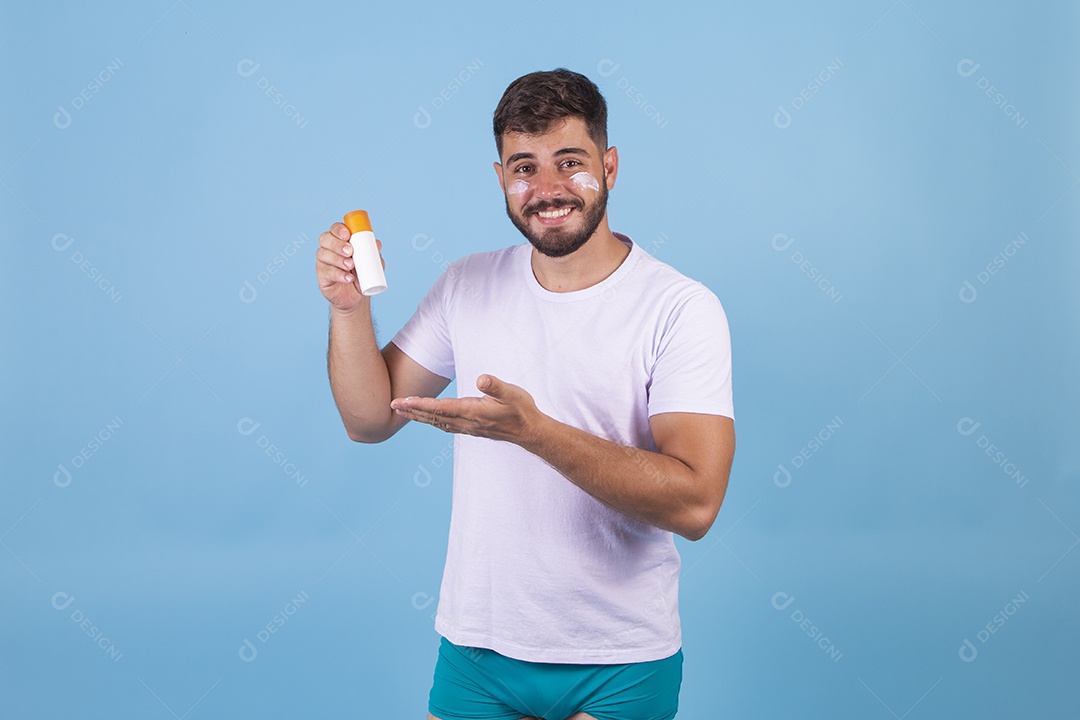 Homem jovem usando produto para o rosto sobre fundo isolado