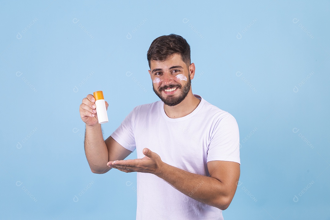 Homem jovem usando produto para o rosto sobre fundo isolado