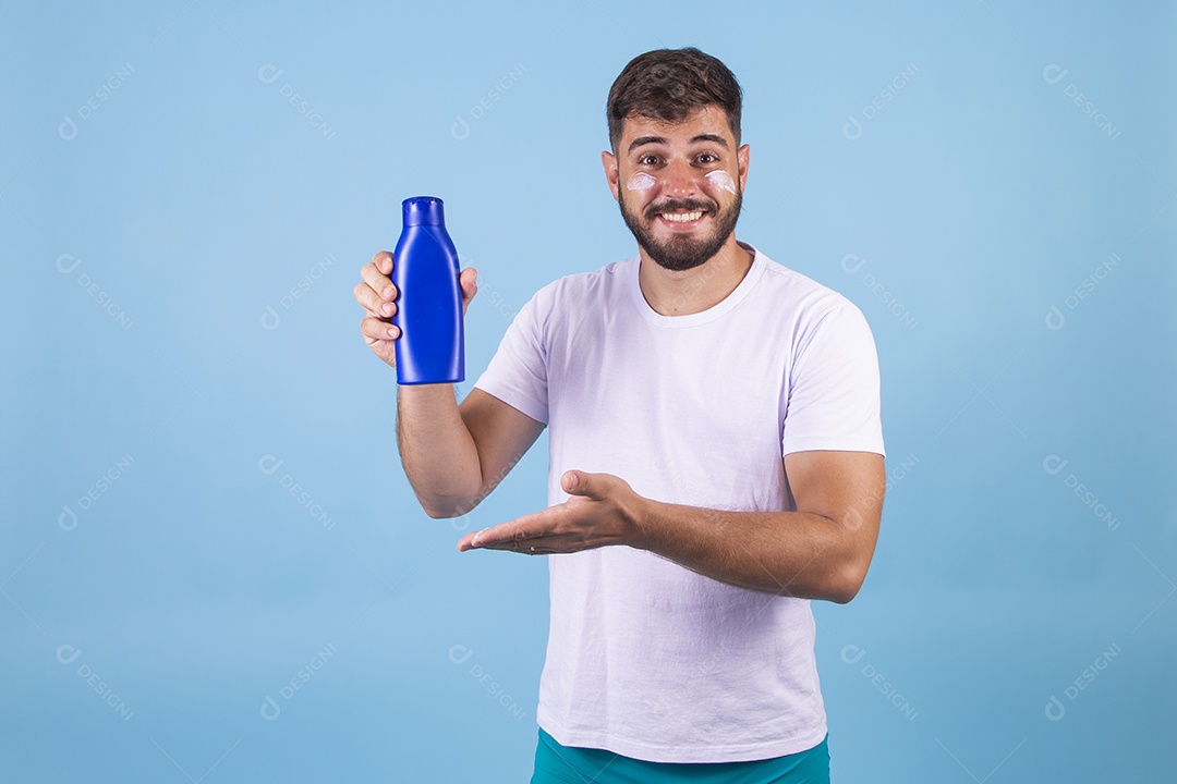 Homem jovem usando produto para o rosto sobre fundo isolado