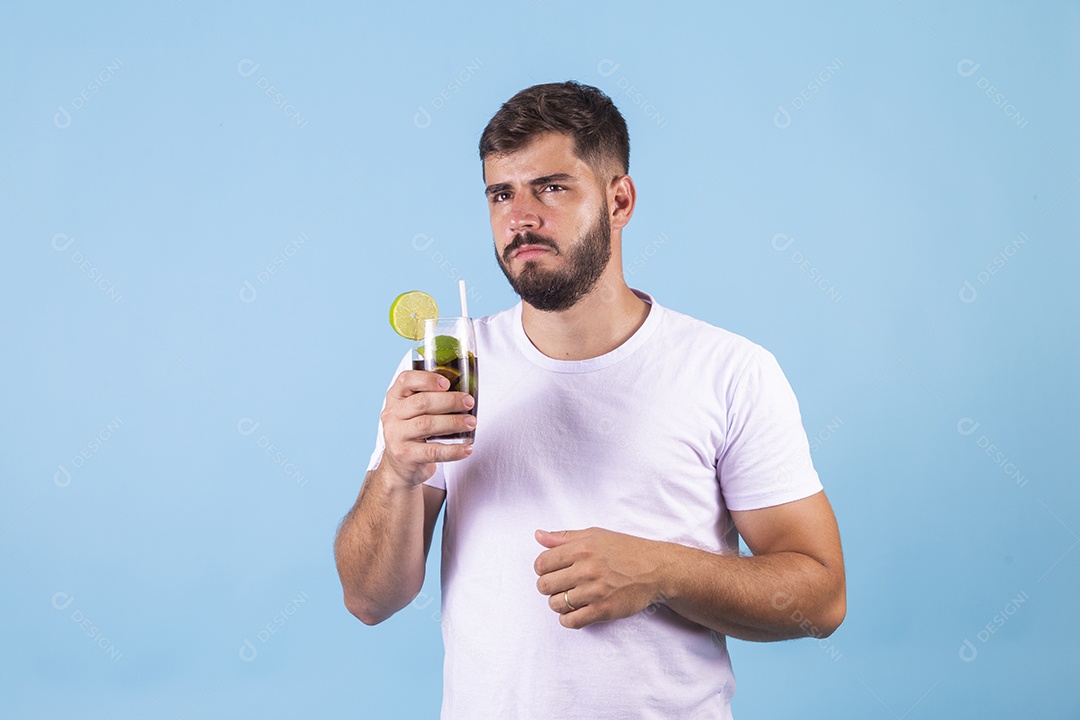 Homem jovem segurando copo de bebida sobre fundo isolado