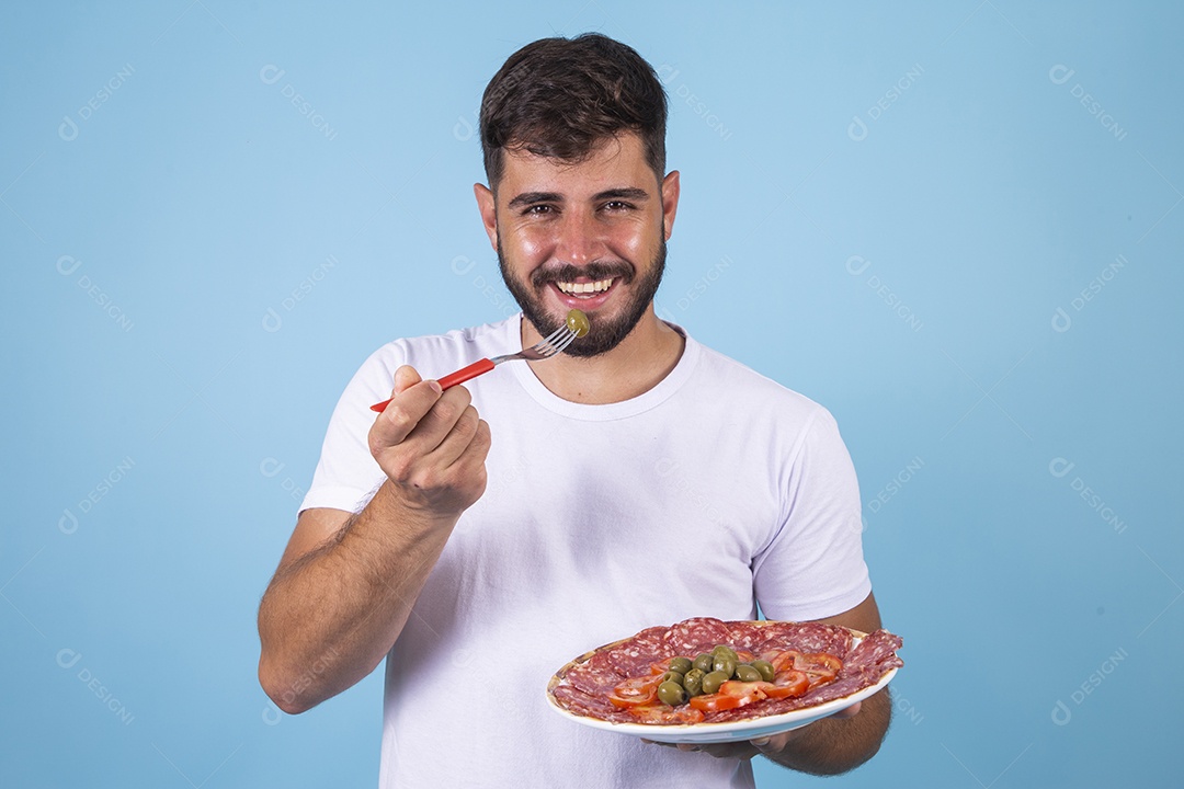 Homem jovem se alimentando com salame sobre fundo isolado