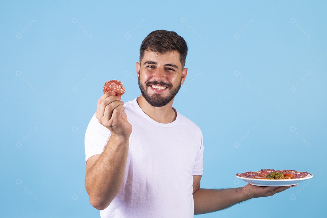 Homem jovem segurando prato de salame sobre fundo isolado