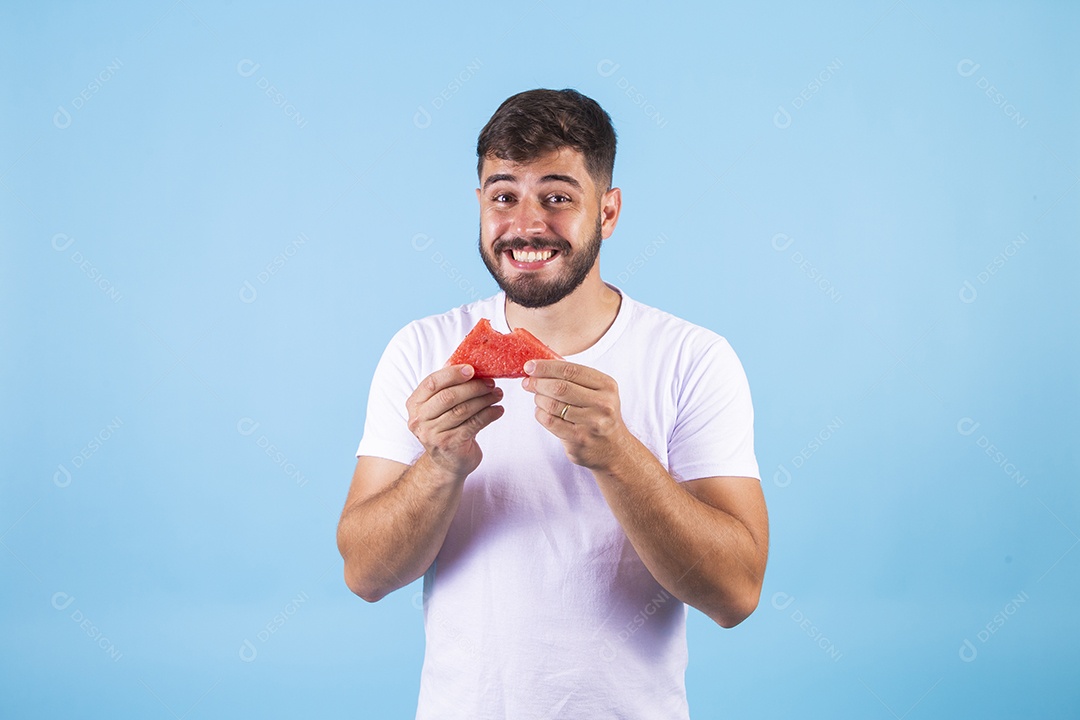 Homem jovem se alimentando com melancia sobre fundo isolado