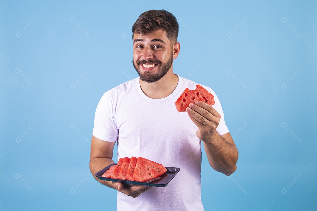 Homem jovem se alimentando com melancia sobre fundo isolado