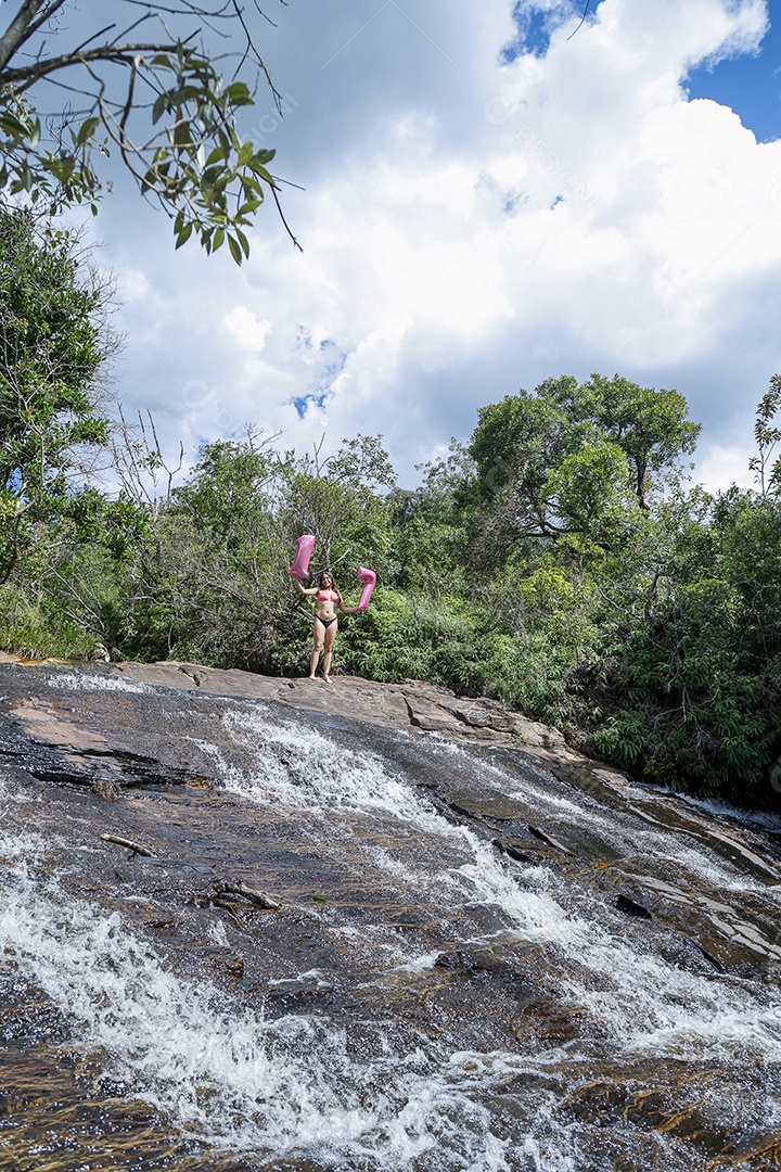 Linda mulher jovem fazendo aniversario completando 17 anos sobre cachoeira
