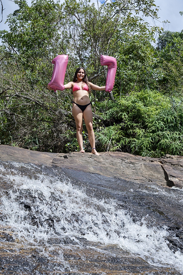 Linda mulher jovem fazendo aniversario completando 17 anos sobre cachoeira