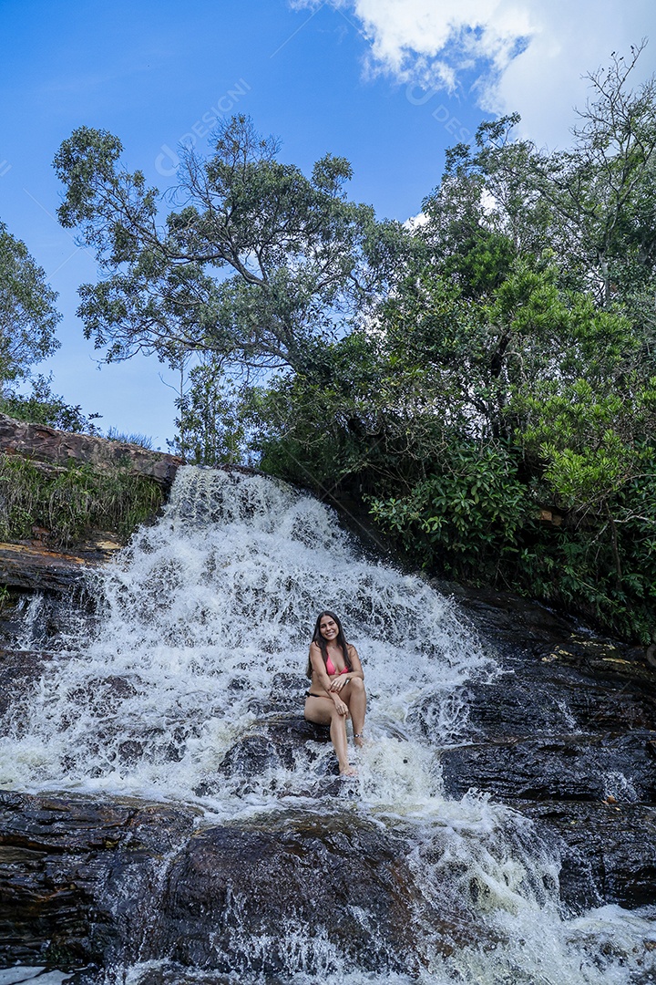Linda mulher jovem usando biquíni sobre cachoeira