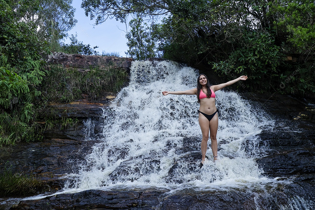 Linda mulher jovem fazendo aniversario completando 17 anos sobre cachoeira