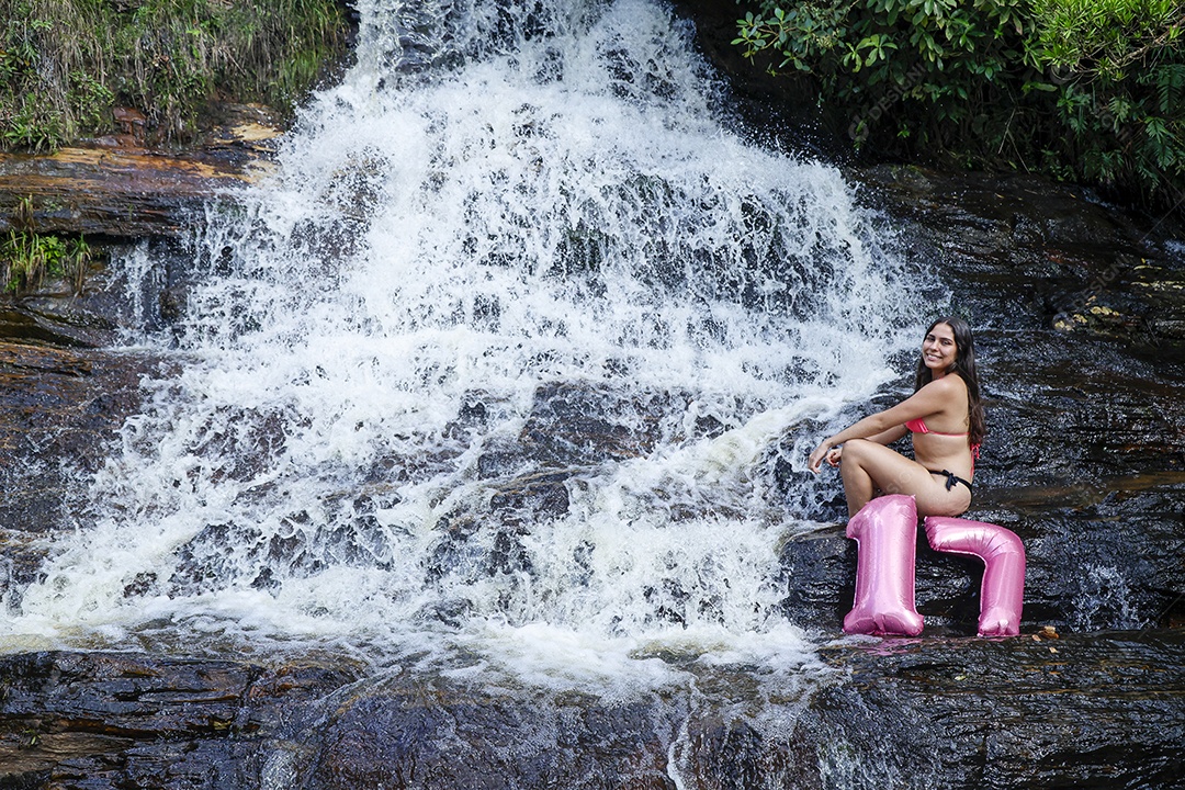 Linda mulher jovem fazendo aniversario completando 17 anos sobre cachoeira