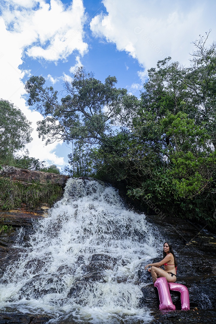 Linda mulher jovem fazendo aniversario completando 17 anos sobre cachoeira