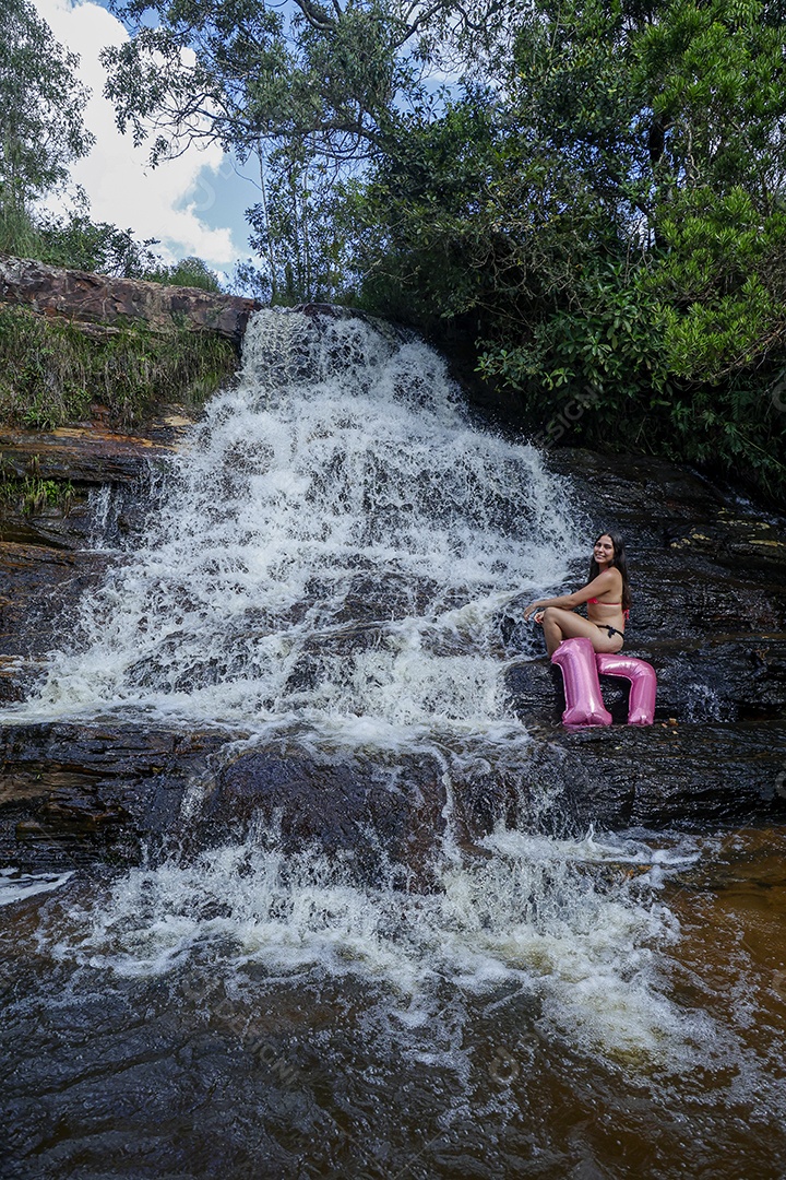Linda mulher jovem fazendo aniversario completando 17 anos sobre cachoeira