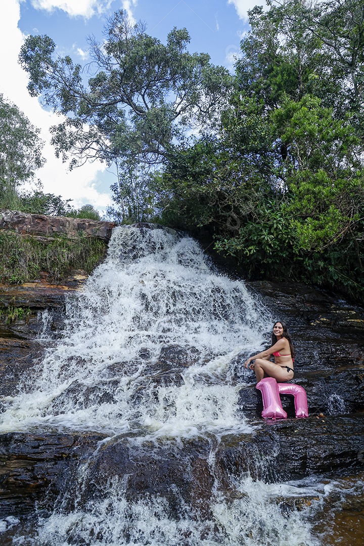 Linda mulher jovem fazendo aniversario completando 17 anos sobre cachoeira