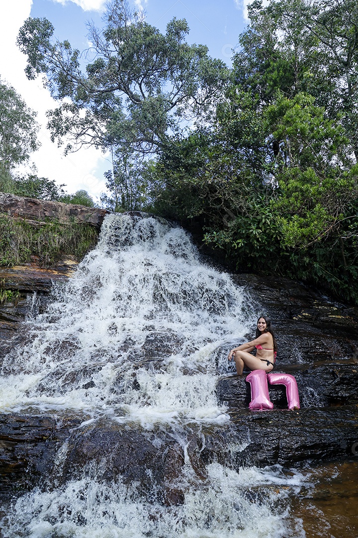 Linda mulher jovem fazendo aniversario completando 17 anos sobre cachoeira