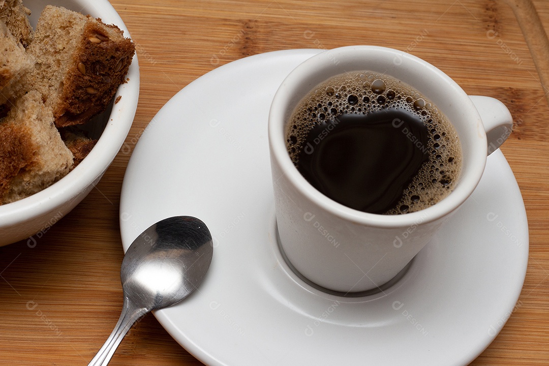 Xícara de café com tigela cheia de torradas