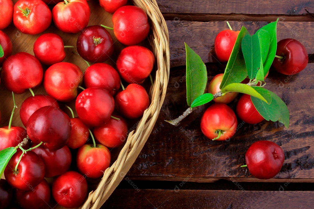 Acerola cereja baga fresca na cesta na mesa de madeira rústica.