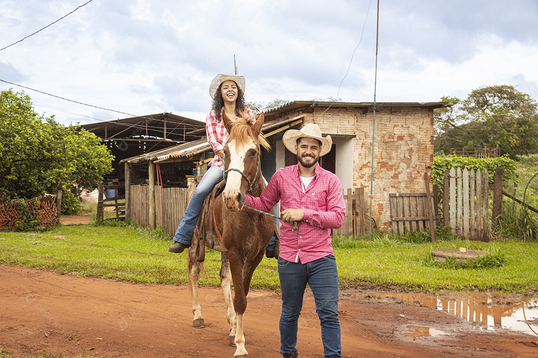 Casal de jovens sobre fazenda andando a cavalo sobre fazenda