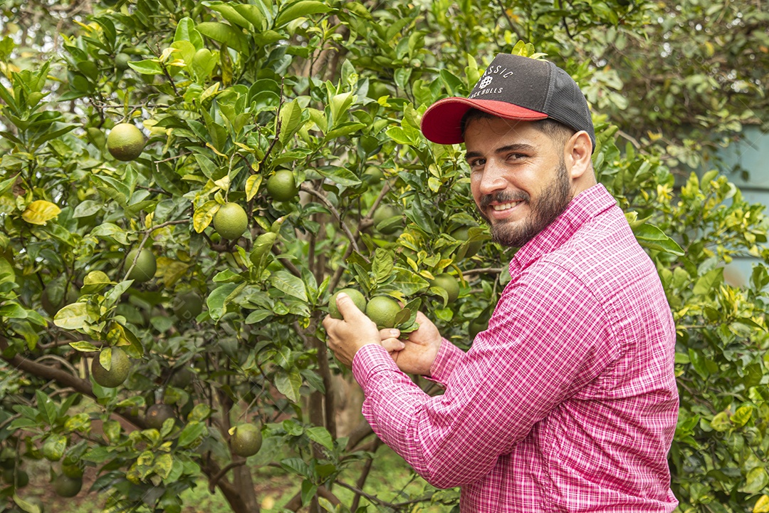 Homem jovem agricultor segurando fruta
