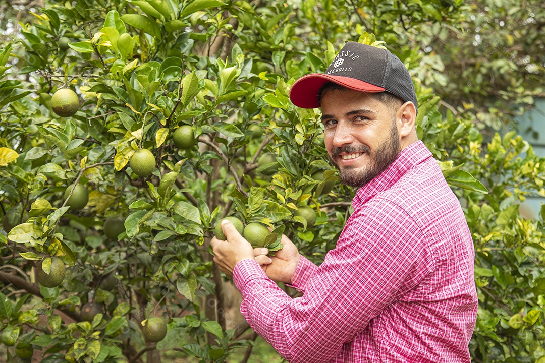 Homem jovem agricultor segurando fruta