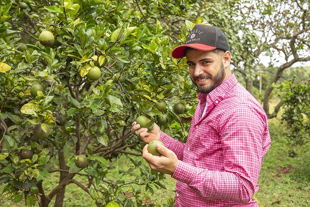 Homem jovem agricultor segurando fruta