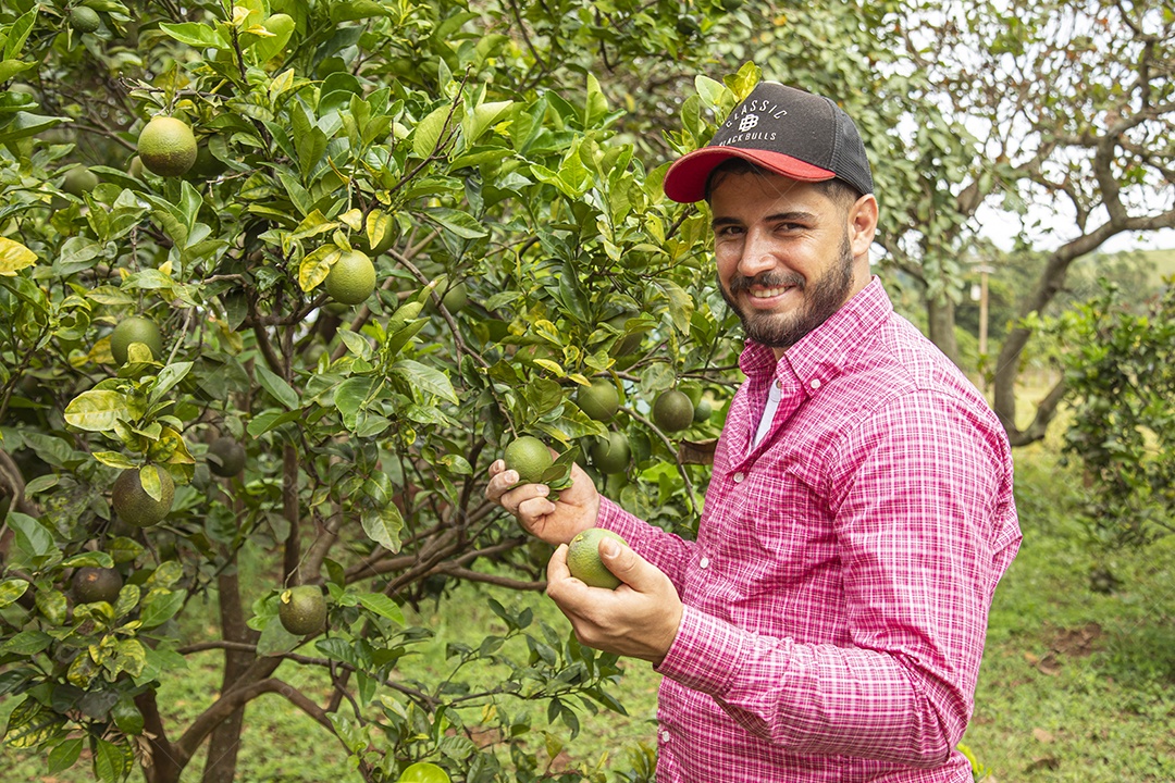 Homem jovem agricultora segurando fruta