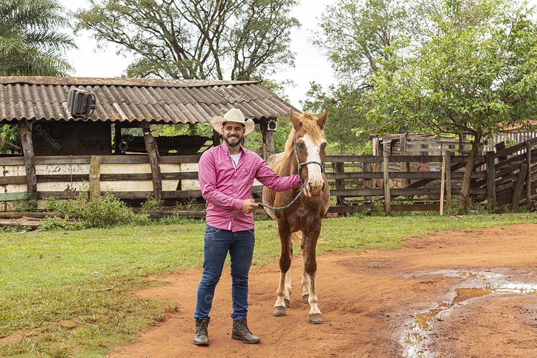 Homem jovem agricultor sobre fazenda com seu cavalo