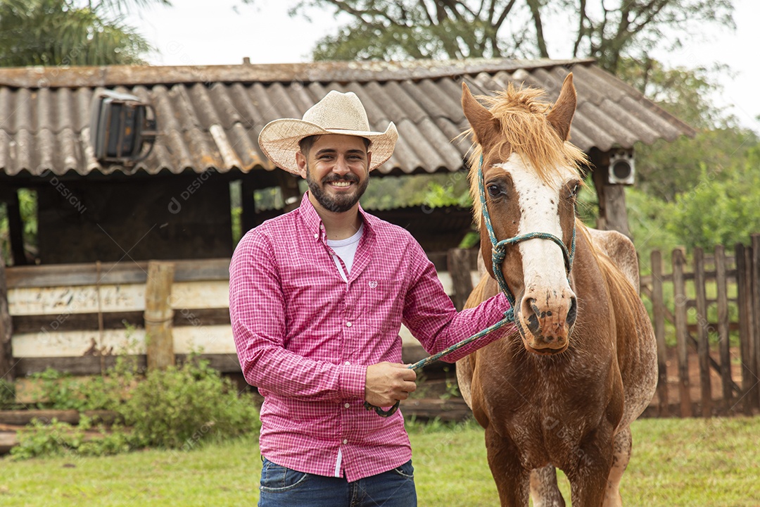 Homem jovem agricultor sobre fazenda com seu cavalo