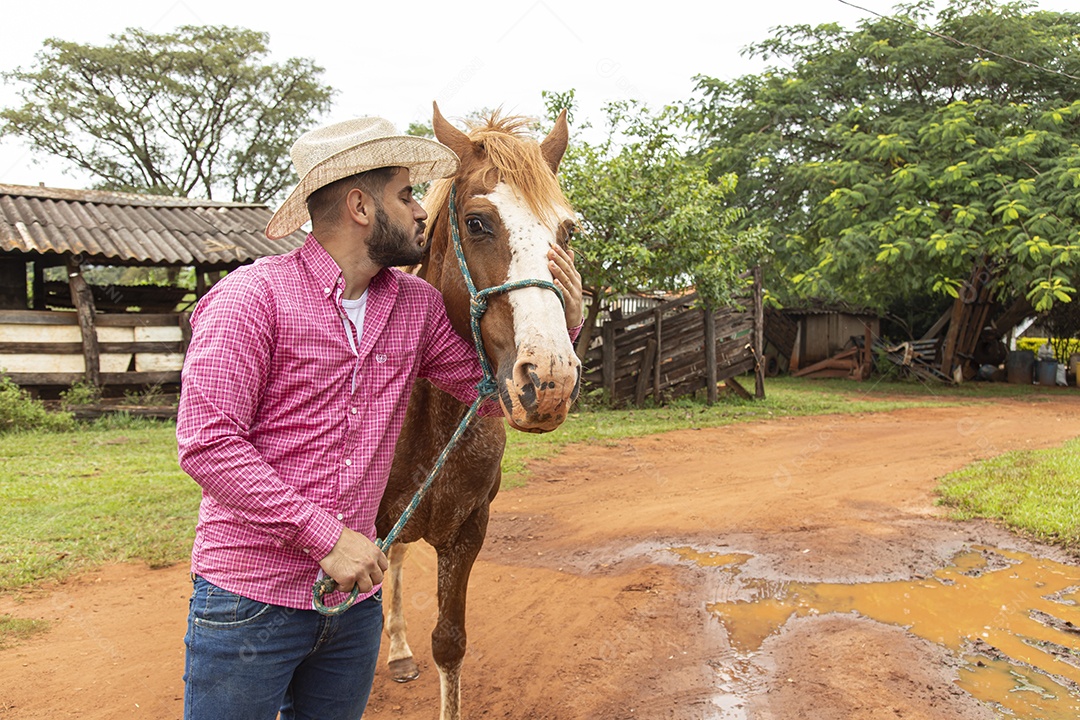 Homem jovem agricultor sobre fazenda com seu cavalo