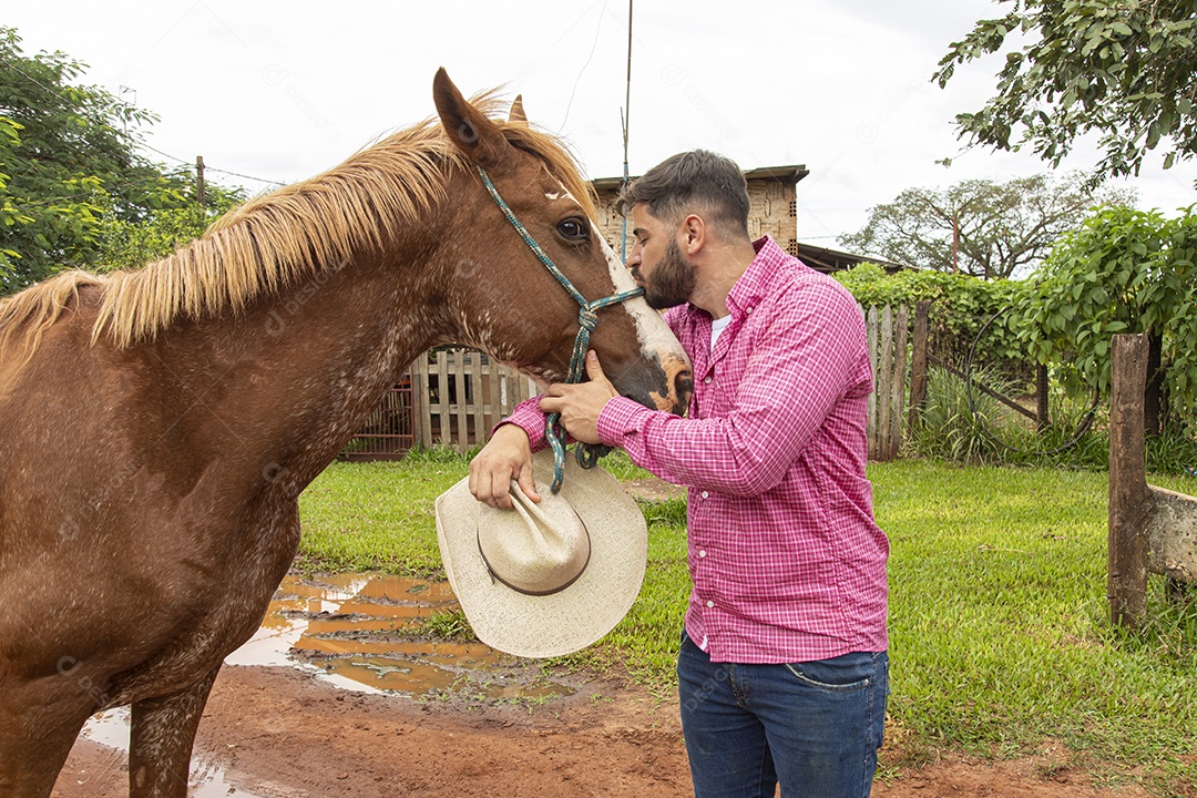 Homem jovem agricultor sobre fazenda com seu cavalo