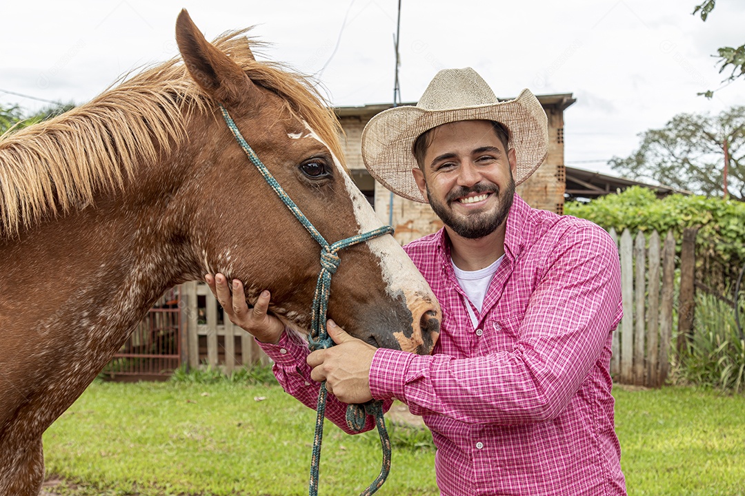 Homem jovem agricultor sobre fazenda com seu cavalo