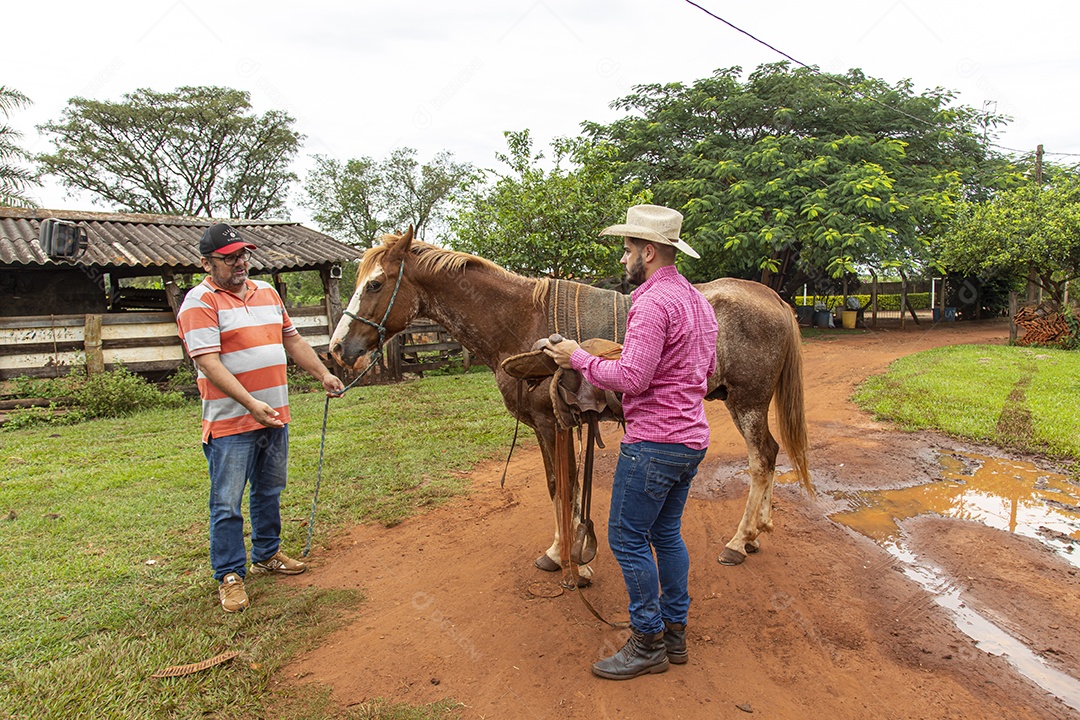 Homem jovem agricultor sobre fazenda com seu cavalo