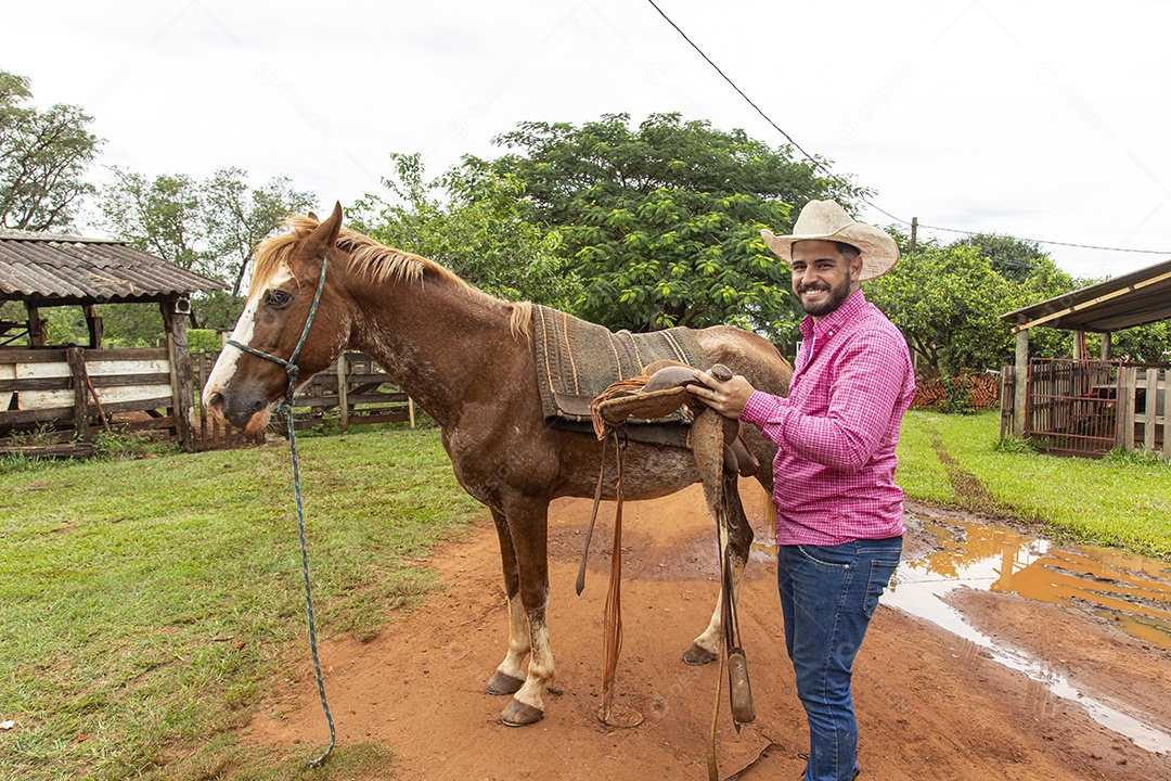 Homem jovem agricultor sobre fazenda com seu cavalo