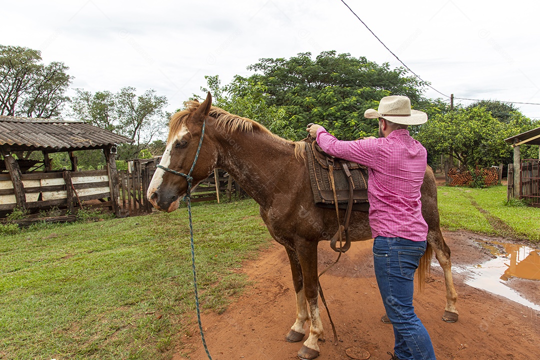 Homem jovem agricultor sobre fazenda com seu cavalo