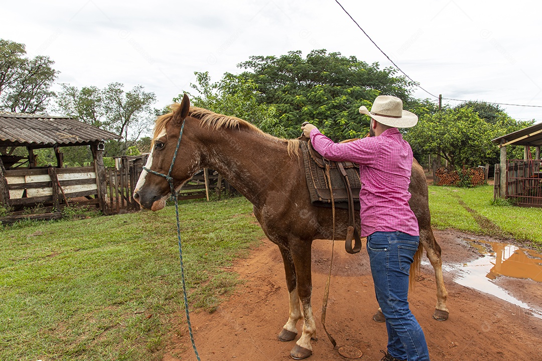 Homem jovem agricultor sobre fazenda com seu cavalo