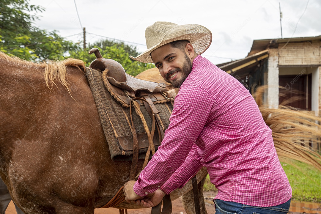 Homem jovem agricultor sobre fazenda com seu cavalo