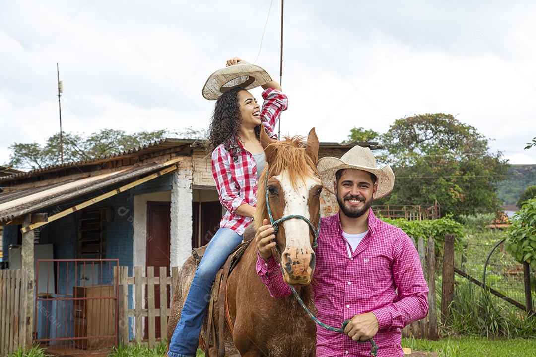 Casal de jovens sobre fazenda andando a cavalo sobre fazenda