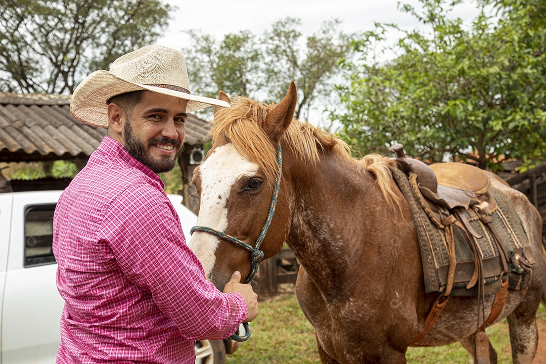 Homem jovem agricultor sobre fazenda com seu cavalo
