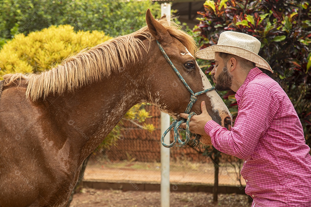 Homem jovem agricultor sobre fazenda com seu cavalo