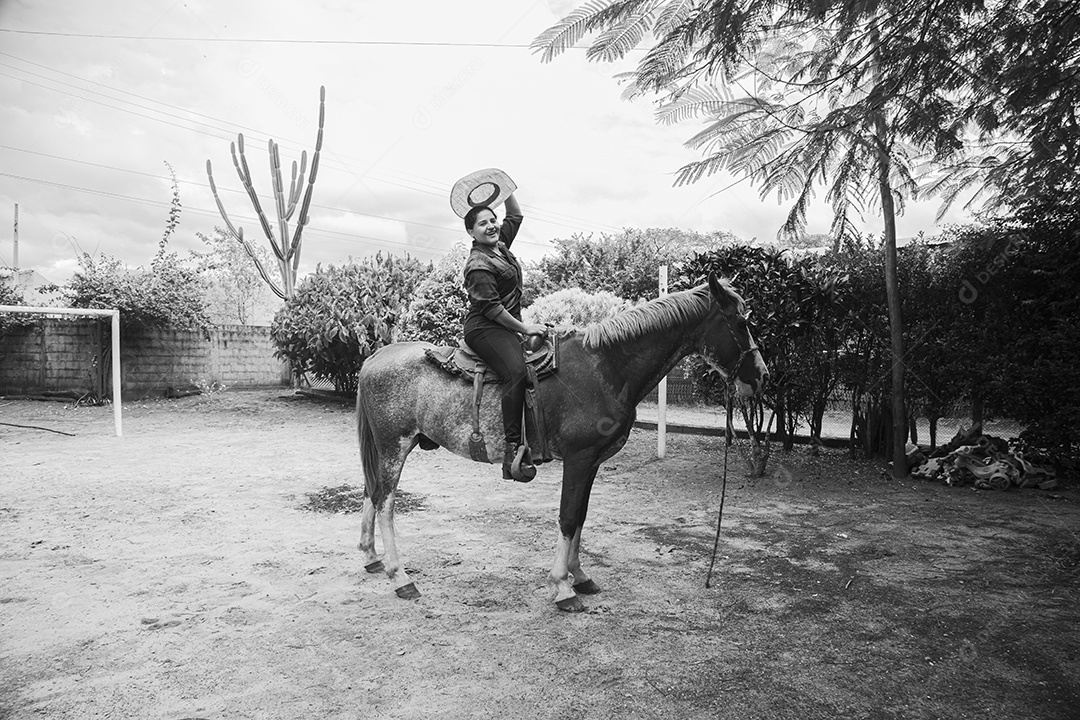 Mulher jovem agricultora sobre fazenda com seu cavalo