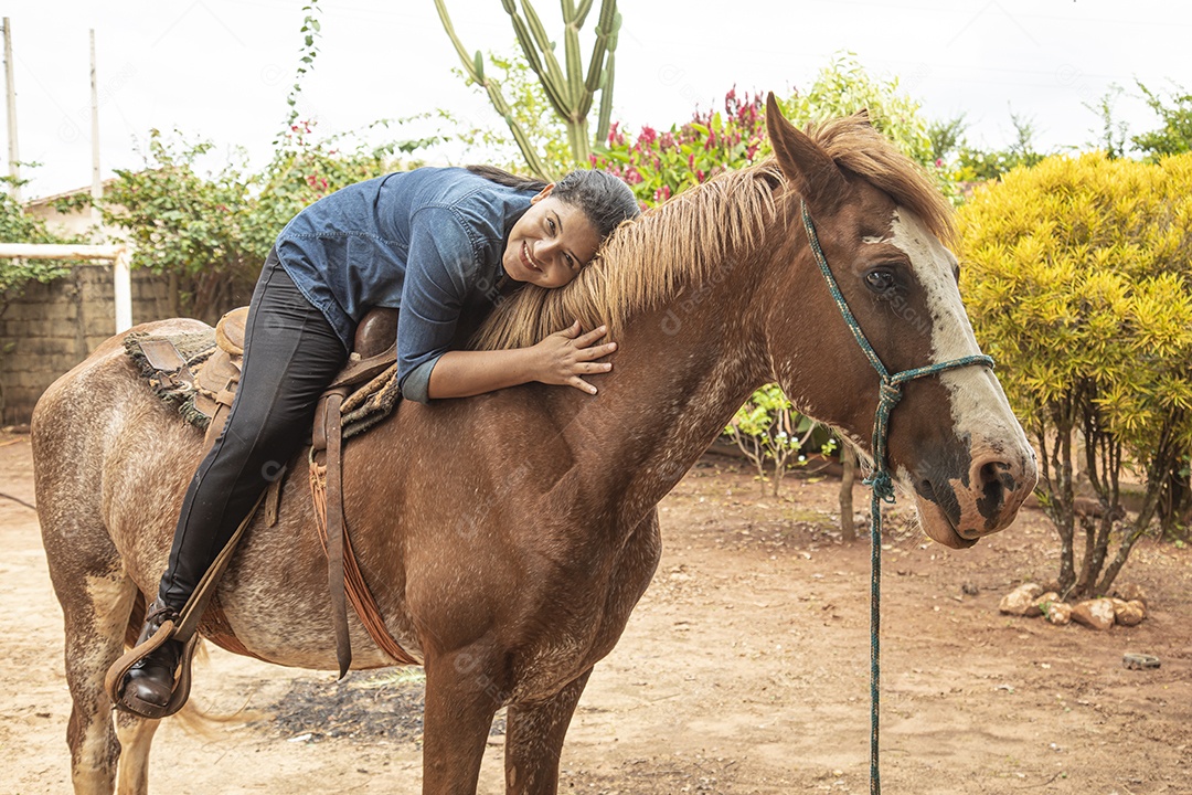 Mulher jovem agricultora sobre fazenda com seu cavalo