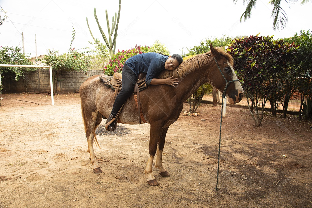 Mulher jovem agricultora sobre fazenda com seu cavalo