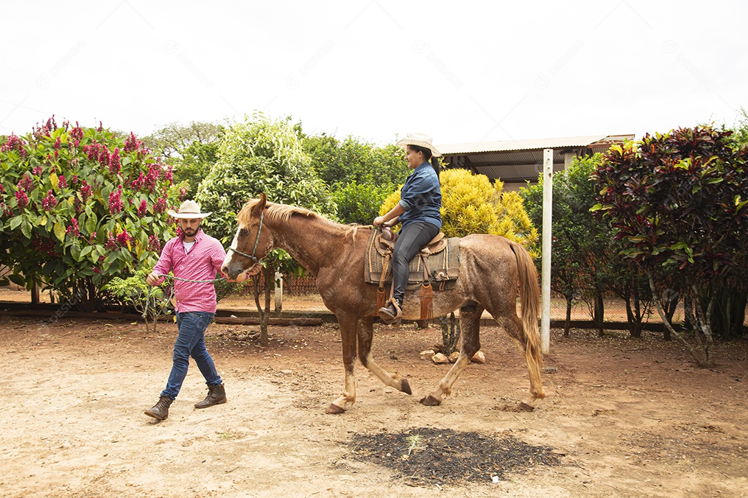 Mulher jovem agricultora sobre fazenda com seu cavalo