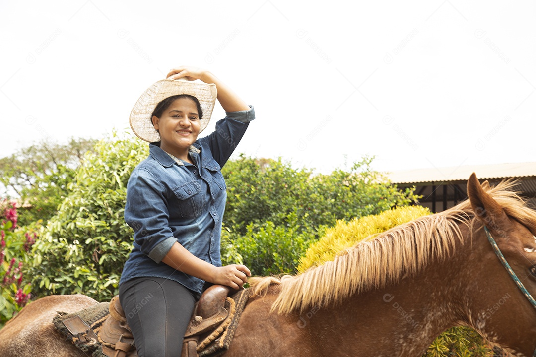 Mulher jovem agricultora sobre fazenda com seu cavalo