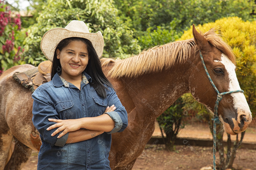 Mulher jovem agricultora sobre fazenda com seu cavalo